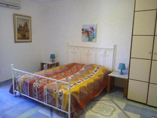 a bedroom with a bed and two tables with lamps at Villa Regale B e B Country House in Piano di Santa Laura