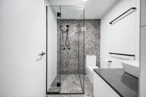 a bathroom with a shower and a toilet and a sink at Beachcomber Peregian Beach in Peregian Beach
