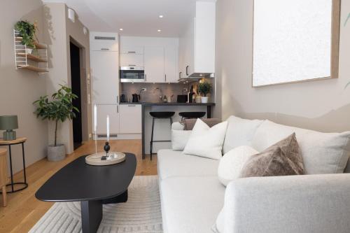a living room with a white couch and a table at Moderne leilighet sentralt på Tromsøya in Tromsø