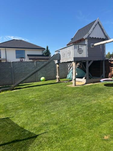 a yard with a playground and a house at Apartament u Dyncyka in Krajno Pierwsze