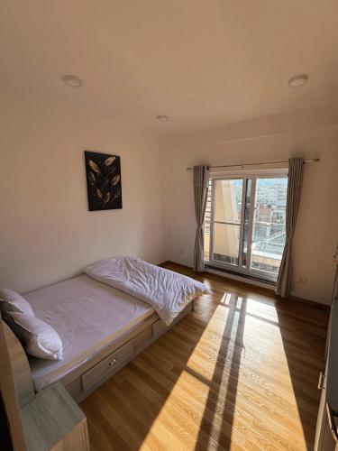 カトマンズにあるThe Crazys Apartmentのベッドと大きな窓のある寝室