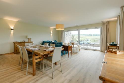 a living room with a dining table and a couch at La Ferme d'Auwez - Horizon - Gîte 6 pers avec piscines et sauna in Ciney