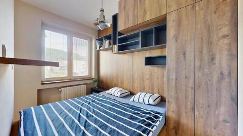 a bedroom with a bed and a wooden wall at The Hideout in Žilina