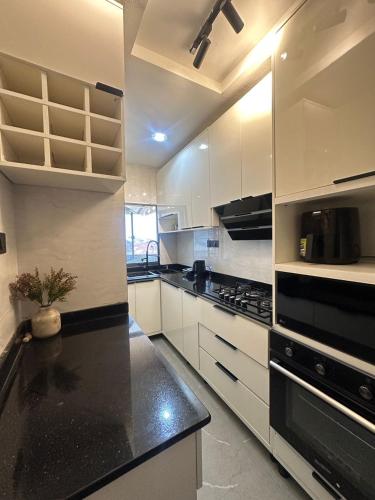 a kitchen with white cabinets and a black counter top at Prisanshortlet in Abuja