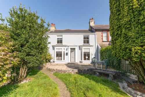 a white house with a pathway leading to it at Coastal Home in Mumbles with Garden & WiFi in Swansea