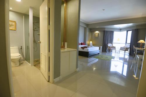 a living room with a bathroom and a bedroom at Napalai Hotel in Udon Thani