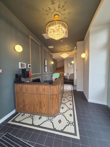 a lobby with a reception desk and a chandelier at Hôtel l'Hermine - Vannes Port de plaisance in Vannes