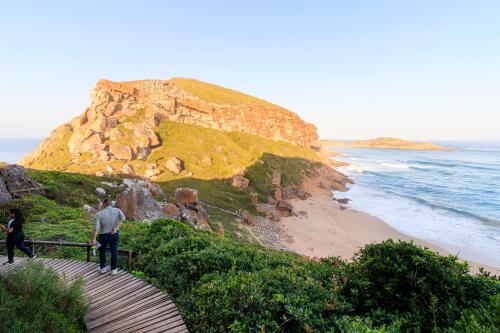 a man and woman walking down a stairs to a beach at The Plettenberg Hotel in Plettenberg Bay