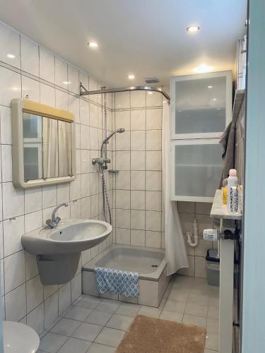 a bathroom with a sink and a bath tub at Helles, gepflegtes Souterrain Apartment in ruhiger Lage in Düsseldorf