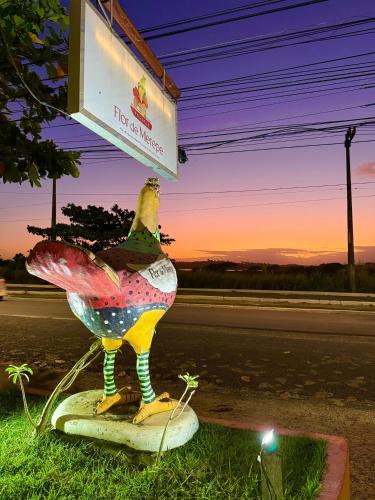 a statue of a chicken on the side of a road at Pousada Flor de Merepe - Porto de Galinhas in Porto De Galinhas