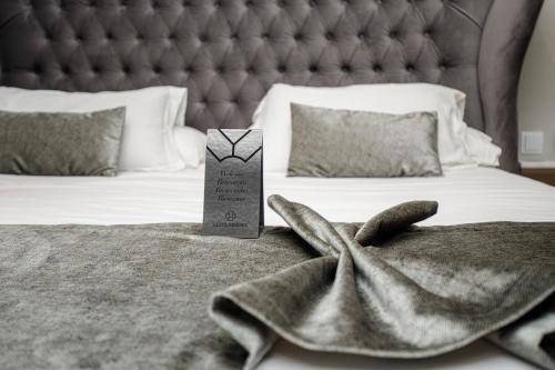 a bed with a large bed with a blanket and a towel at Les Clarisses Boutique Hotel in Vic