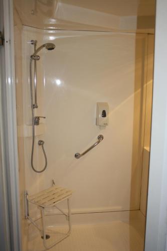 a shower stall in a bathroom with a table at Hôtel Quick Palace Valence Nord in Bourg-lès-Valence