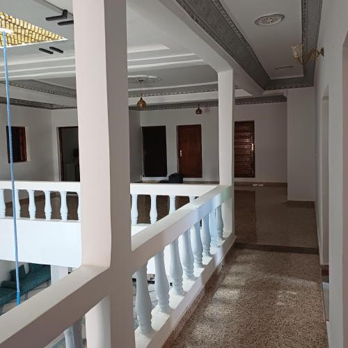 a corridor of a building with white columns at La Belle Vue Guest House in Aït Ben Haddou