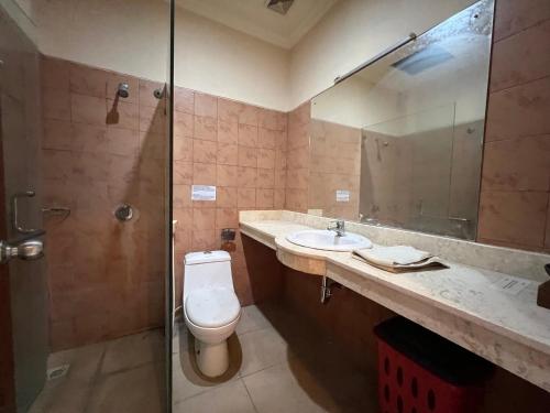 a bathroom with a toilet and a sink and a shower at Collection O Bali near Bajra Sandhi Monument formerly Hotel Puri Samaritan in Denpasar