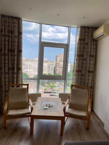a room with two chairs and a table and a large window at Кадор, Жемчужина 3 in Odesa