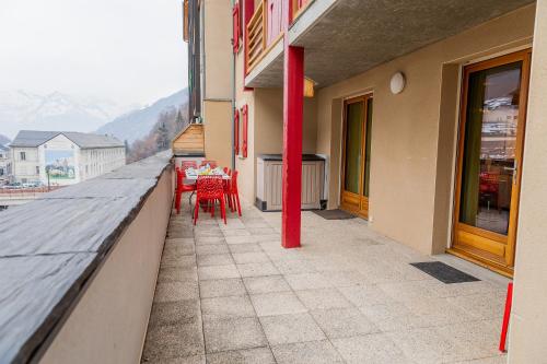 a balcony with red tables and chairs on a building at Appartement Le Bois de Marie in Barèges