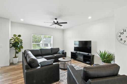 a living room with a couch and a tv at Modern Townhome Retreat in Prime Location townhouse in Coralville