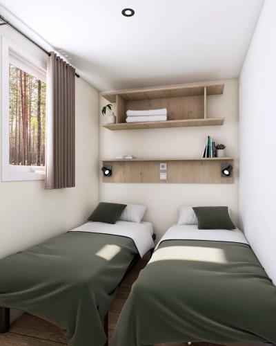 two beds in a room with a window at Camping Le Roc in Vairé