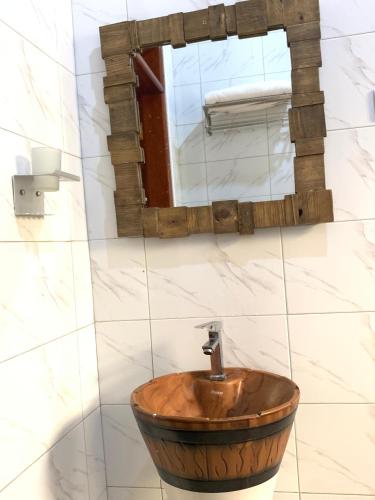 a wooden sink in a bathroom with a mirror at Bugoma Palms Resort Sand Beach 