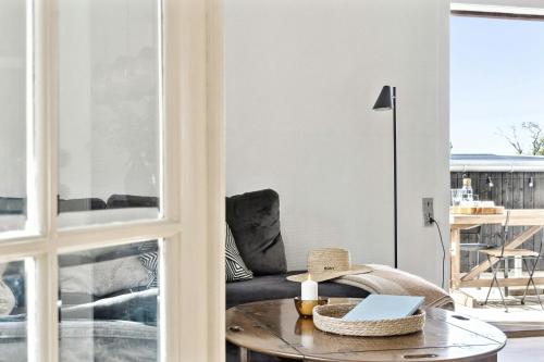 a living room with a table and a couch at Charming Holiday Home On The Island Of Fejø in Vejrø
