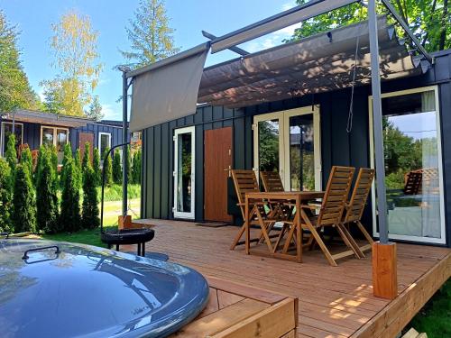 una terraza con bañera de hidromasaje y una casa en Wisla66 Domki nad Wisłą Piotrawin, 