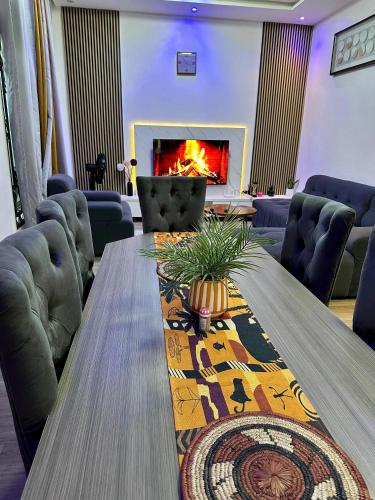 a living room with a table and a fireplace at Résidence Léon Mackenzie in Cocotomey