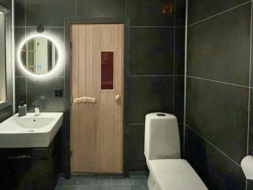 a bathroom with a toilet and a sink and a mirror at Mountain Cabin With Ski Tracks Nearby in Øyer