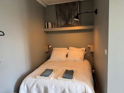 a small bedroom with a bed with two pillows at Le studio du Clos du Bourgage in Saint-Pierre-dʼAutils