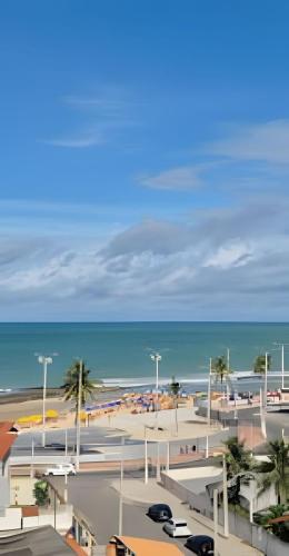 a parking lot next to a beach with the ocean at Apartamento na praia em Natal in Natal