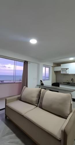 a large bed in a room with a large window at Apartamento na praia em Natal in Natal