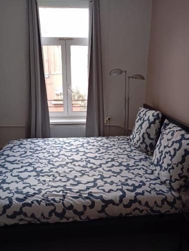 una cama en una habitación con una ventana grande en T2 rénové proche métro, en Lille
