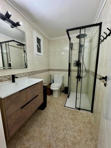 a bathroom with a shower and a sink and a toilet at The Cozy Coast in Piles