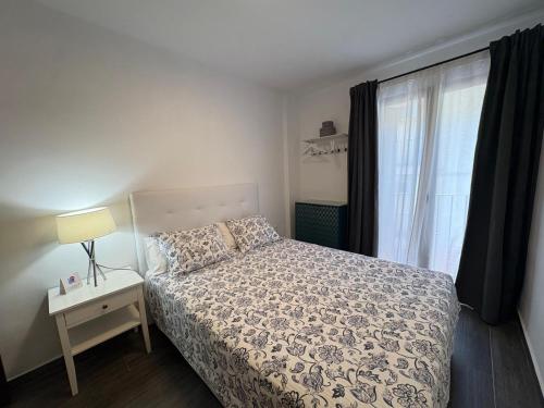 a small bedroom with a bed and a window at II Apartamentos Morales & Arnal in Ronda