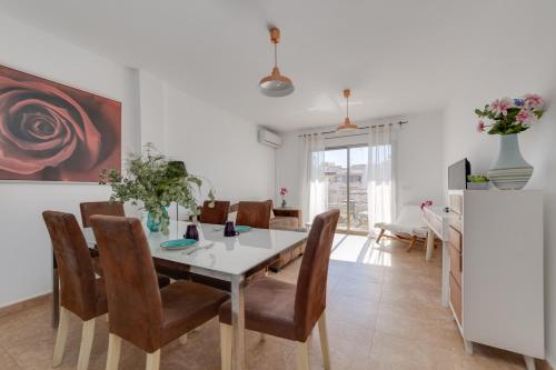 a dining room with a white table and chairs at Apartamentos Madrid in Torrevieja