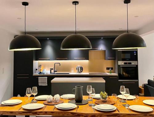 a kitchen with a wooden table with wine glasses at La Chaumine - Beautiful & Stylish 2 Floor Apartment With Terrace in Montriond