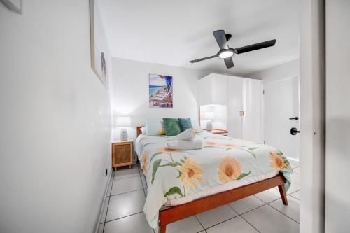 a bedroom with a bed and a ceiling fan at Beachcomber Peregian Beach in Peregian Beach