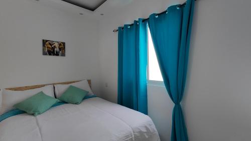 a bedroom with a blue curtain and a bed at Azure Breeze Hotel in Bayahibe