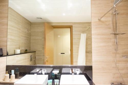 a bathroom with two sinks and a shower at 2-Bed Apartment with Infinity Pool in Dubai