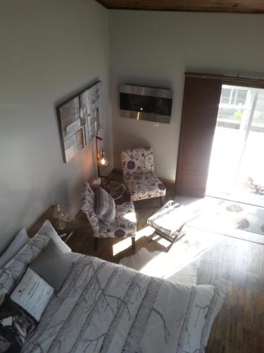 a bedroom with a bed and a couch and a tv at Domaine de la Baie, Les Suites in Shawinigan