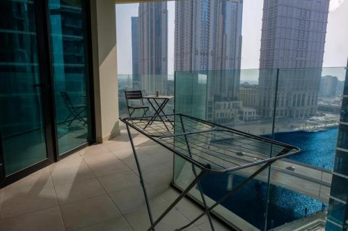 a balcony with a glass table and chairs on a building at 2-Bed Apartment with Infinity Pool in Dubai