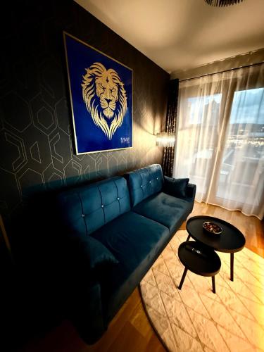 a living room with a blue couch and a lion painting at Andy's apartment in downtown Metropolis with parking in Nivy