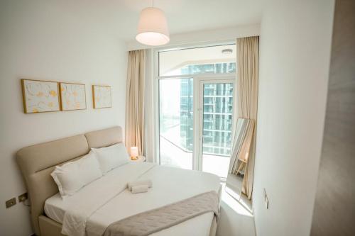 a bedroom with a bed and a large window at 2-Bed Apartment with Infinity Pool in Dubai