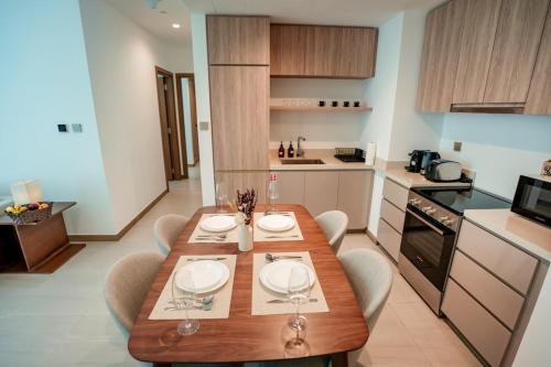 a kitchen with a wooden table and chairs in a room at 2-Bed Apartment with Infinity Pool in Dubai