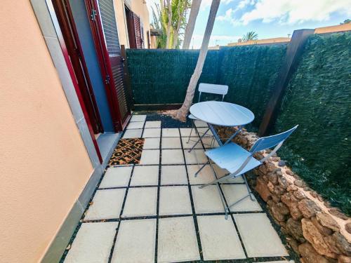 a table and a chair on a patio with a tree at Ulisse Suite in Corralejo