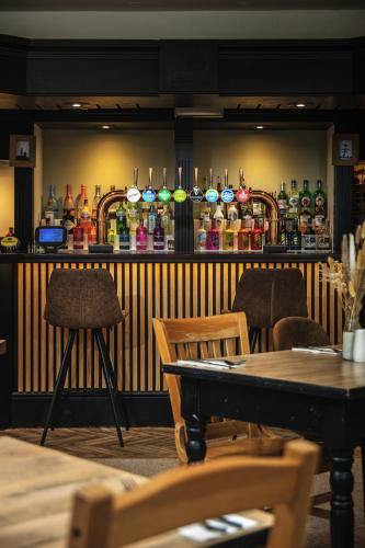 a bar with a lot of bottles on the wall at Inn For All Seasons in Redruth