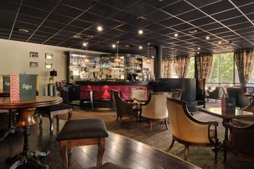 a restaurant with tables and chairs and a bar at Hôtel Marso in Amnéville
