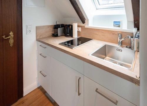 a small kitchen with a sink and a window at Sylter Wohlfühlnest, App 2 in Wenningstedt
