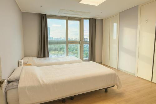two beds in a hospital room with a window at E 2BR 60m2 Newly Built High Floor APT 2min to Hyundai Outlet Triple St 2Free Parking in Incheon