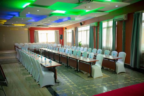 a row of tables and chairs in a room with green lights at Tiffany Diamond Hotels Ltd - Indira Gandhi street in Dar es Salaam