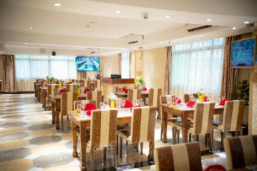a dining room with wooden tables and chairs at Tiffany Diamond Hotels Ltd - Indira Gandhi street in Dar es Salaam